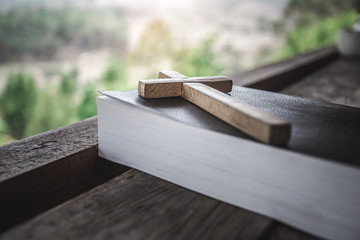 Close up wooden cross on the Bible. christian symbol concept.