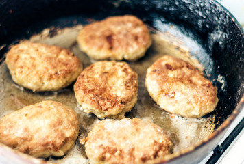 homemade fried minced meat cutlets are roasting in a frying pan in oil.