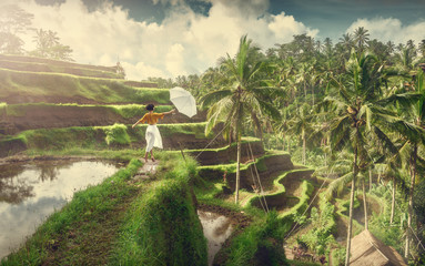 Girl with an umbrella on the rice terraces. Rice fields Tegallalang. A girl in a white dress. Bali Journey. Travel. Adventure.