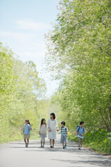 Fototapeta premium 一本道を歩く小学生と先生