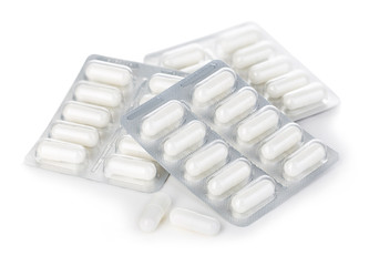 Capsule pills in blister pack close-up isolated on a white background.