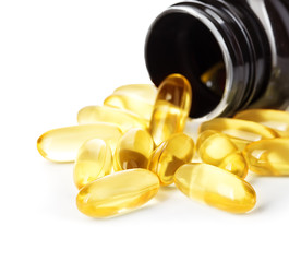 Pills spilling out of pill bottle close-up isolated on a white background.