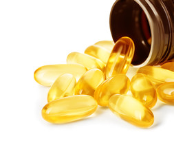 Pills spilling out of pill bottle close-up isolated on a white background.