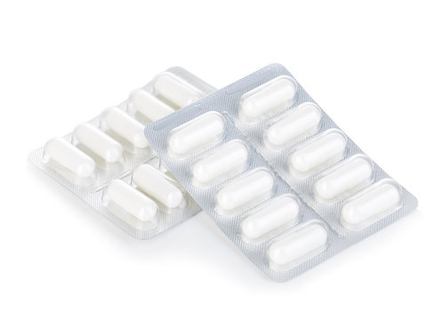 Capsule pills in blister pack close-up isolated on a white background.