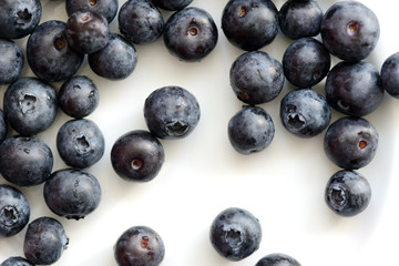 Fresh blueberry berries on a white plate close up. Top view