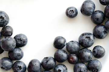 Fresh blueberry berries on a white plate close up. Top view