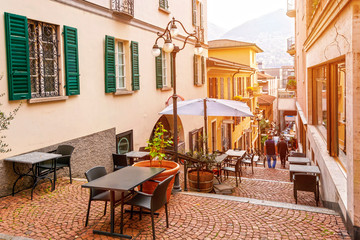 Narrow street with cafes and restaurants in the old town of Lugano, canton of Ticino, Switzerland.