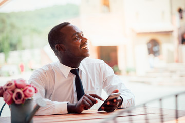 African business man smiling with using smartphone
