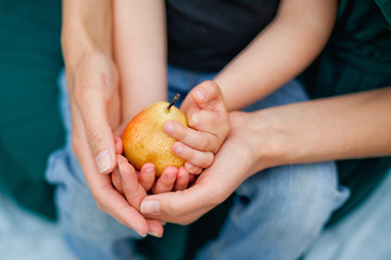 woman and child holding a pear