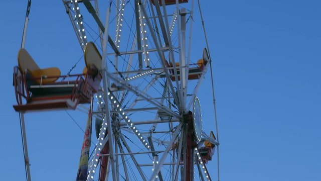 4K view of Ferris Wheel rides rotating, spinning in amusement park