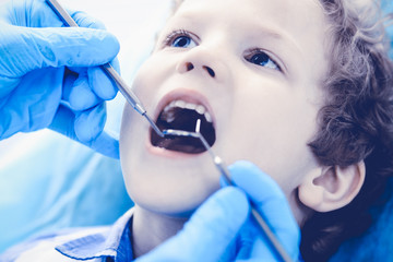 Doctor and patient child. Boy having his teeth examined with dentist. Medicine, health care and stomatology concept