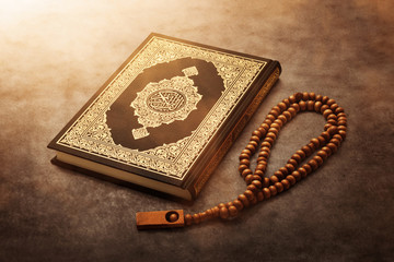 Quran holy book with rosary beads