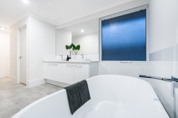Large modern bathroom interior with high end fittings and stand alone bathtub. PERTH, AUSTRALIA. MAY 2019.