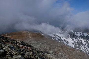 Babia Gora - mountain range in Beskid Zywiecki during spring with fog, clouds and sun