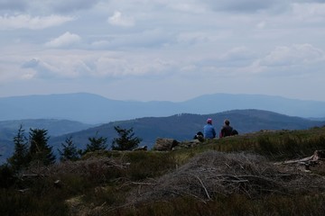Fototapeta premium Beskid Zywiecki during spring - sitting tourists are waching view from hill Cyl Hali Smietanowej near Zawoja