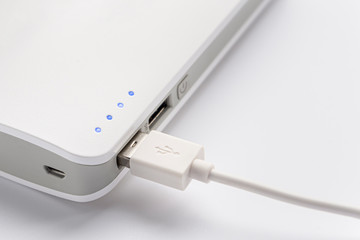USB plug. Close up of portable battery connected with charging cable. Portable charger.
