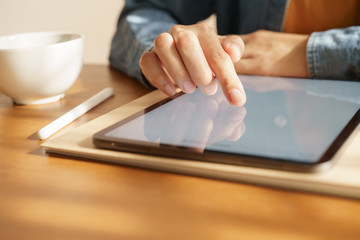 Asian women are playing tablets on the table.