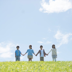 草原で手をつなぐ小学生