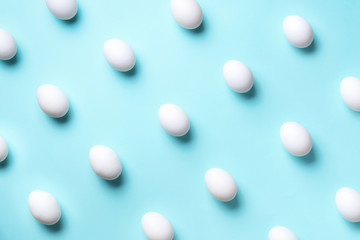 Food concept with white chicken eggs on blue background. Top view. Creative pattern in minimal style. Flat lay.