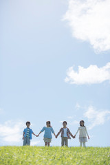 草原で手をつなぐ小学生