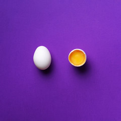 Food concept with broken egg and whole one on violet background. Top view. Creative pattern in minimal style. Flat lay. Square crop