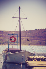 Jetty pier on coastline with boat yacht.