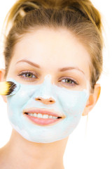 Girl apply green mud mask to face