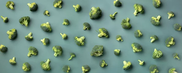 Kreatives Layout von frischem Brokkoli auf grünem Papierhintergrund. Ansicht von oben. Lebensmittelmuster im minimalistischen Stil. Flach liegen. Banner © jchizhe