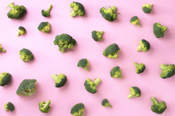 Creative layout of fresh broccoli on pink paper background. Top view. Food pattern in minimal style. Flat lay.