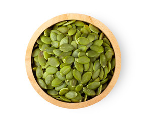 Pumpkin seeds in wood bowl isolated on a white background. top view