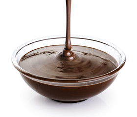 Melted chocolate pouring into a bowl isolated on white background.