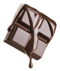 Melted chocolate pours into a piece of chocolate bar isolated on white background.