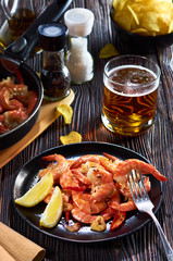 seafood at the bar, composition of black plate with shrimp lemon beer chips