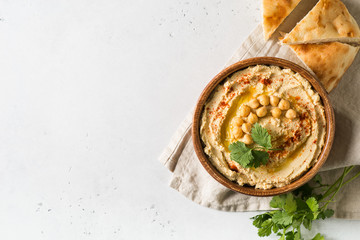 Hummus dip with chickpea, pita  and parsley in wooden plate on white background - obrazy, fototapety, plakaty