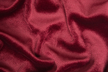 Red velvet background with waves on it. Abstract textile decoration