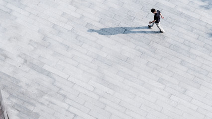 top aerial view people walk on across pedestrian concrete with black silhouette shadow on ground, concept of social still life.