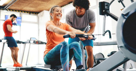 Personal trainer helping a young beautiful woman