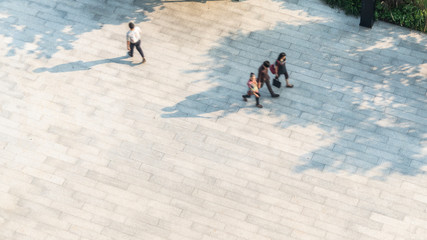 top aerial view blur people walk on across pedestrian concrete with black silhouette shadow on...