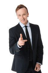 Handsome stylish businessman pointing at viewer on white background