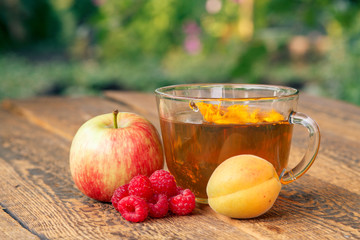 Ripe fruits and cup of green tea on wooden boards