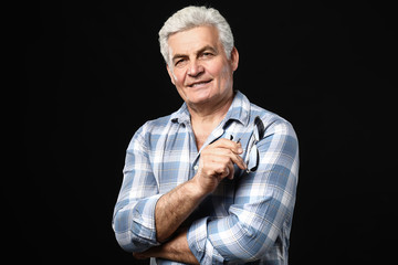 Portrait of handsome senior man on dark background