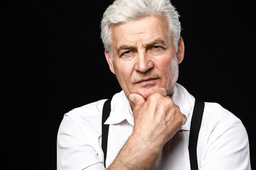 Portrait of thoughtful senior man on dark background