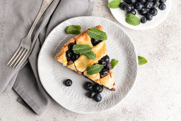 Piece of tasty blueberry pie on light background