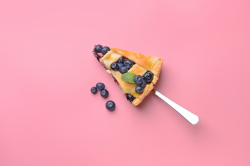 Piece of tasty blueberry pie on color background