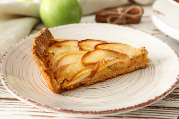 Plate with tasty apple pie on table