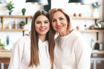 Happy mother and daughter in kitchen at home