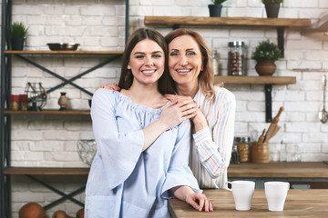 Happy mother and daughter in kitchen at home