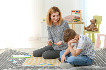 Female psychologist working with boy suffering from autistic disorder