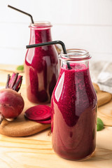 Bottles of fresh beet smoothie on table