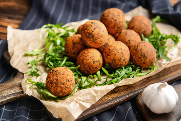 Tasty falafel balls and arugula on board